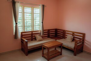 A corner room with a wooden sofa and a small table.