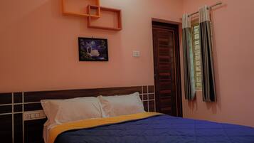 Una camera da letto con un letto, un comodino, una mensola a parete, un quadro e una finestra con tende.