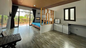 A modern room with a bed, a small kitchenette, a dining table, and a large window offering a view of the outdoors. - Thu Hien Hotel Pleiku - by BAY LUXURY (Gao)