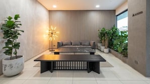 Ein modernes Interieur mit einer Couch, einem Couchtisch und Topfpflanzen.