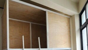 A room with a built-in wooden wardrobe, a white ladder, and a herringbone-patterned wooden floor. - So Art Hostel (Sanyi)