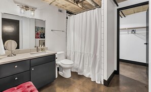 A bathroom with a white sink, a mirror, a toilet, and a shower curtain. - Hebrews 13:2- Wonderful 2 bedroom condo downtown Waco, Baylor, Silos (Waco)