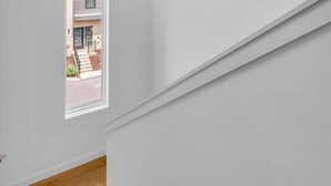 A room with a white wall and a window.