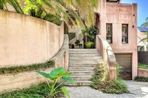 A modern staircase with a concrete wall on one side and a metal gate on the other.