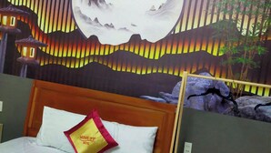 Una habitación de hotel con una cama, una mesita de noche y un mural en la pared.