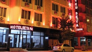 A multi-story hotel with illuminated signage, a car parked in front, and a visible entrance. - Seta Park Hotel (Inegöl)