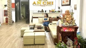 A living room with a sofa, a coffee table, and a decorative Buddha statue. There is a sign with the name "ANCHI VILLA" on the wall. - An Chi Hotel SG - by BAY LUXURY (Ho Chi Minh City)