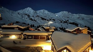 A snow-covered mountain village at night with illuminated buildings and a clear view of the surrounding peaks. - Pégase 407 - Le Cima - Duplexe luxe Belle Plagne (La Plagne-Tarentaise)