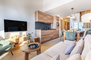 A modern living room with a sofa, a coffee table, and a TV.
