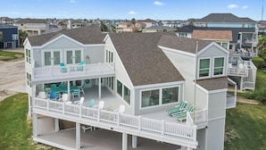 A two-story house with a covered deck and multiple windows. - Cala Tortuga Beachfront Elevator, Hot Tub, Great Views (Galveston)
