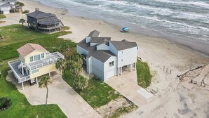 A beachfront property with multiple houses, a sandy beach, and the ocean. - Cala Tortuga Beachfront Elevator, Hot Tub, Great Views (Galveston)