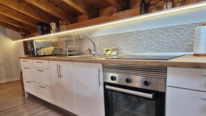 A modern kitchen with a stainless steel oven, a built-in sink, and wooden cabinets. - C26A01 Apto Moderno en Tagle (Tagle)