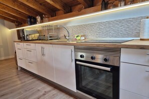 A modern kitchen with a stainless steel oven, a built-in sink, and wooden cabinets. - C26A01 Apto Moderno en Tagle (Tagle)