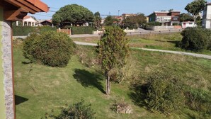 A residential area with houses, a grassy lawn, and a paved walkway. - C26A01 Apto Moderno en Tagle (Tagle)