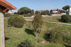 A residential area with houses, a grassy lawn, and a paved walkway. - C26A01 Apto Moderno en Tagle (Tagle)