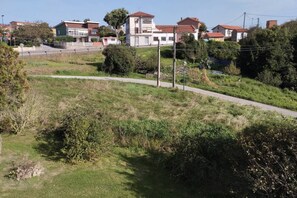 Ett bostadsområde med hus, en asfalterad gångväg och lite grönska.