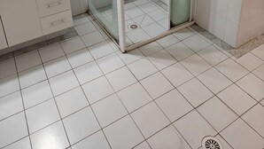 A bathroom with a glass-enclosed shower, a white sink, and a tiled floor. - Sydney City Extra Large furnished Apartment  (Haymarket)