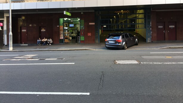 A building with a storefront and a parked car. - Sydney City Extra Large furnished Apartment  (Haymarket)