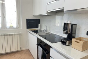 A modern kitchen with a blackboard, a coffee machine, and a wooden box on the counter.