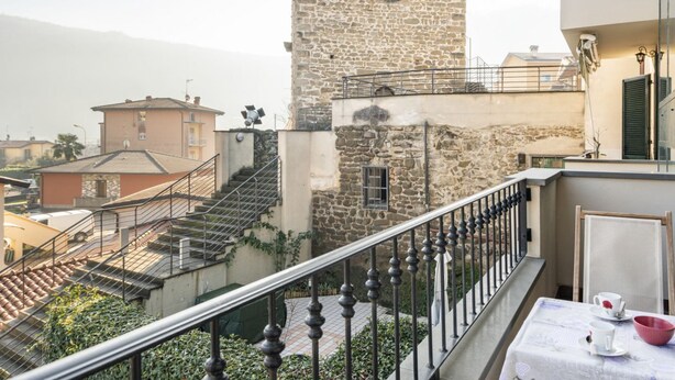 Ein Balkon mit einem für Tee gedeckten Tisch, ein Stein-Turm und eine Treppe, die zu einer weiteren Ebene führt.
