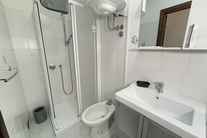 Een douche, een haardroger, een bidet, handdoeken