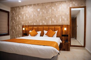Ein Hotelzimmer mit einem großen Bett, einem Holzkopfende und einer Wand mit Muster.