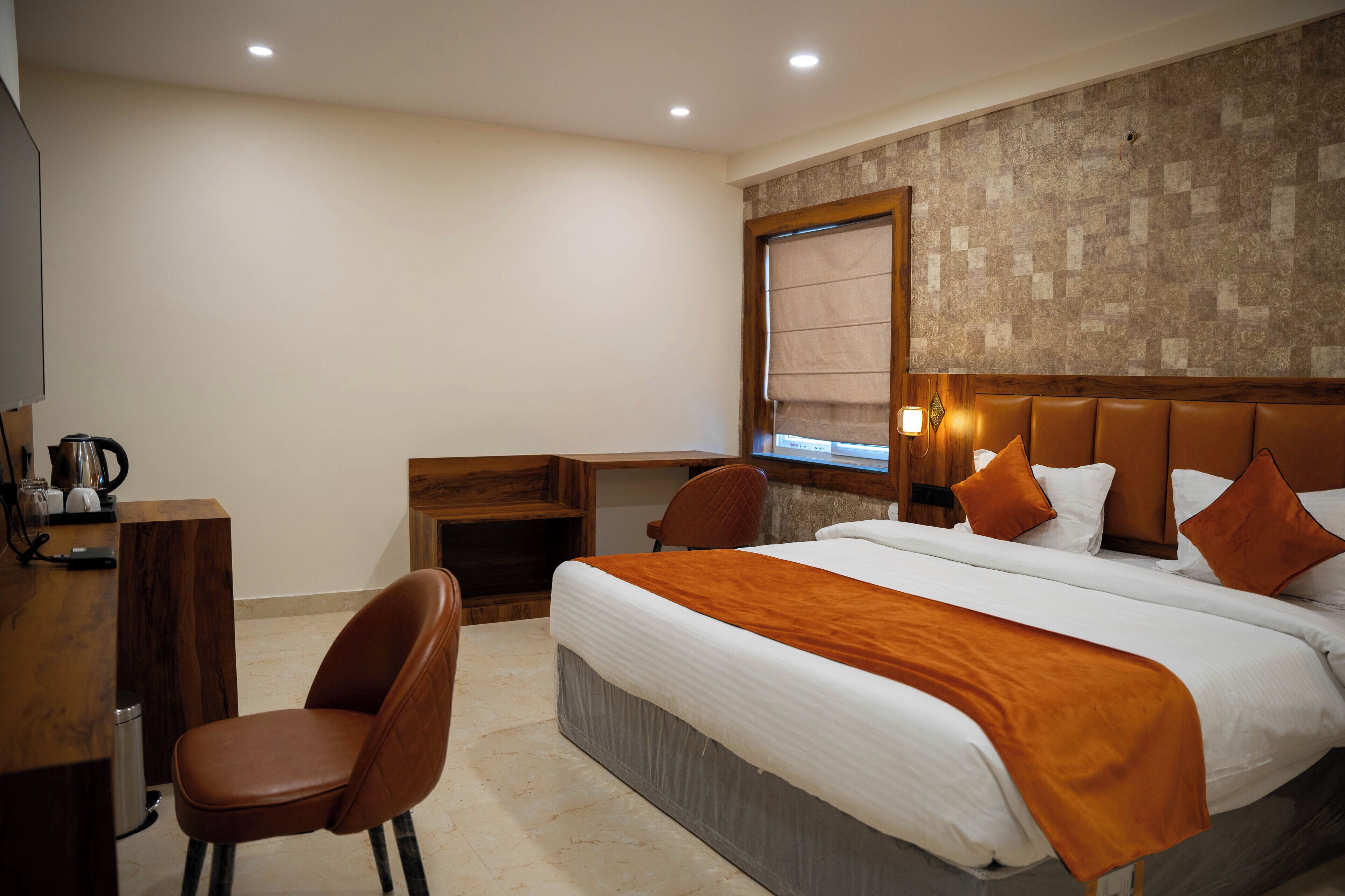Ein Hotelzimmer mit Bett, Schreibtisch, Stuhl und Fenster mit Blick.