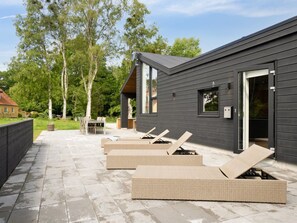 Relax in the outdoor lounge area with wicker chairs and a stone-tiled patio.