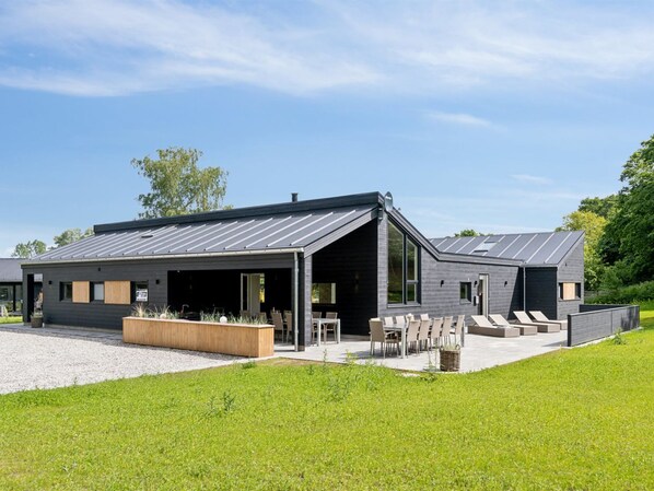 Relax in the spacious outdoor area with a covered patio and seating, perfect for unwinding or hosting guests.