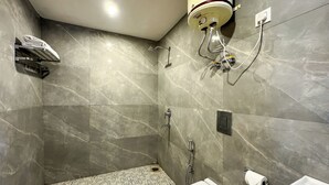 A bathroom with a shower, toilet, and a water heater mounted on the wall. - Hotel Wraveler Inn Mussorrie (Dehradun)
