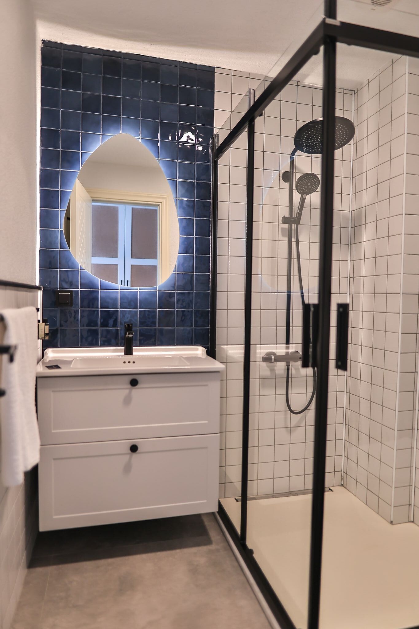A bathroom with a white vanity, a mirror, and a glass-enclosed shower area.