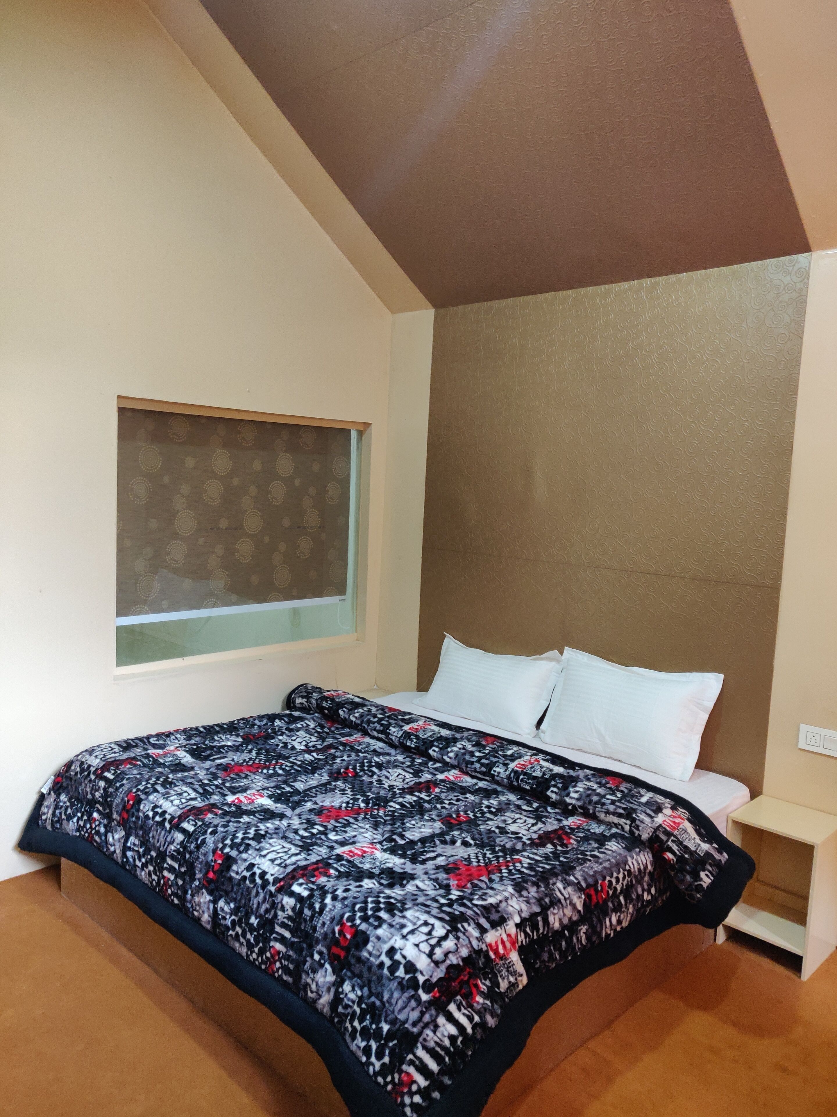 A bedroom with a bed, a window, and a nightstand.
