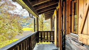 A wooden porch with a view of a green landscape. - Stunning private villa for 5 guests with TV, patio and panoramic view (Niederöblarn)