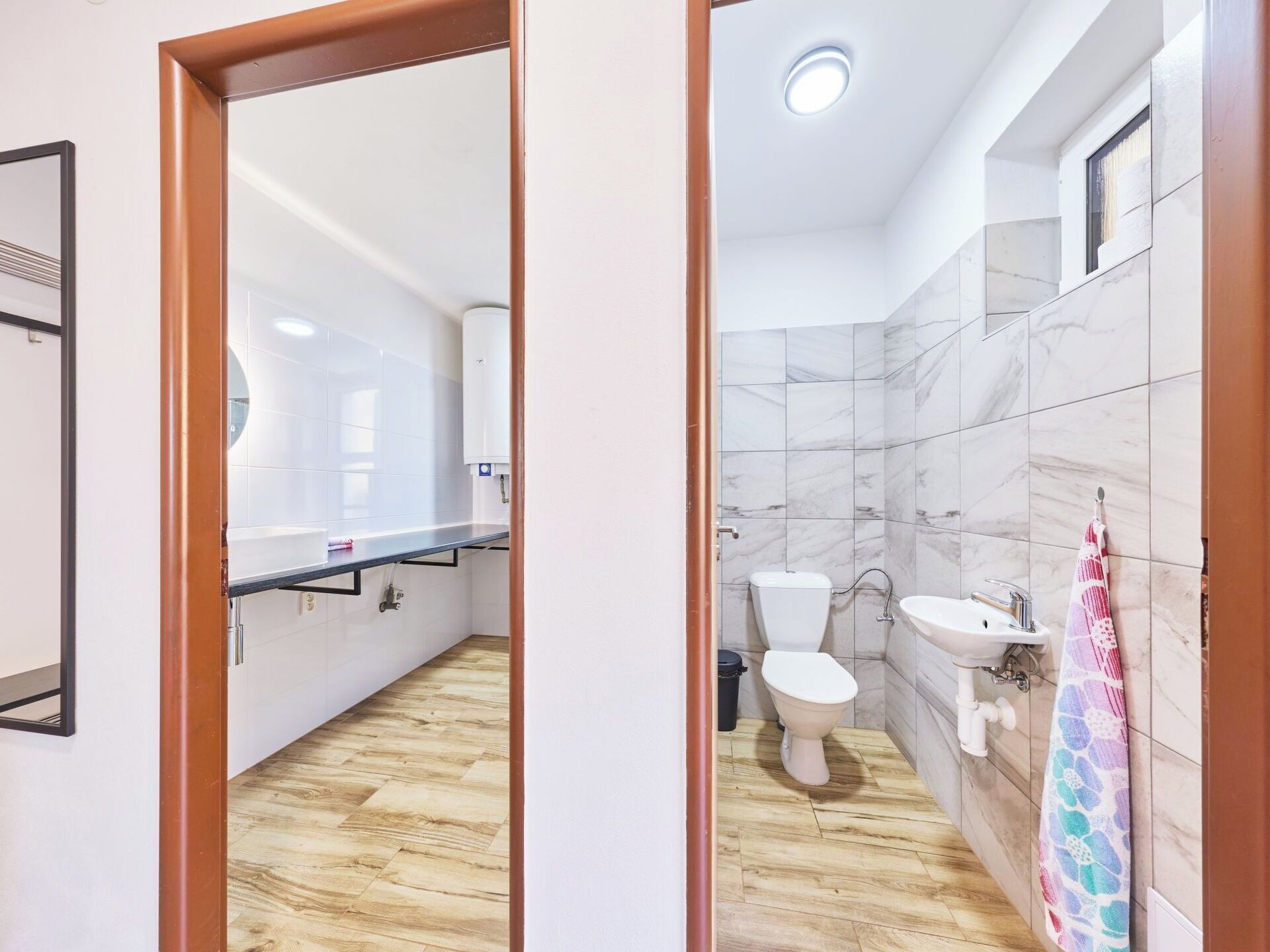 A modern bathroom with a toilet, sink, and mirror.