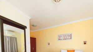 Una habitación de hotel con cama, escritorio, silla, armario y espejo.