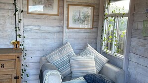 A cozy bedroom with a bed, a wooden dresser, and a window with a view. - Relax at our Lodge in the Cheshire Countryside (Congleton)
