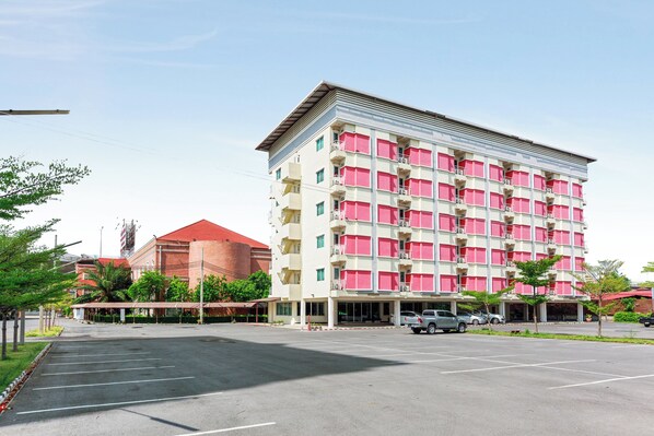 A multi-story hotel with a red roof and pink balconies. - Collection O VResotel (Nonthaburi)