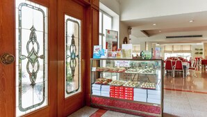 Een bakkerijdisplay met verschillende gebakken producten en een bord waarop 15% korting vermeld staat.