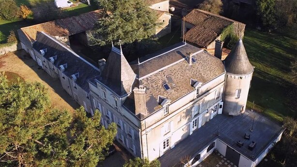 An aerial view of a large, historic building with a central tower, surrounded by trees and a paved courtyard. - Renovated 17th-century château, a unique experience in the Niort countryside (SAIVRES)