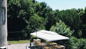 A wooden deck with outdoor seating and a covered area. - Renovated 17th-century château, a unique experience in the Niort countryside (SAIVRES)