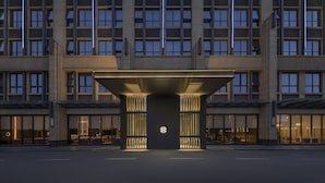 A modern hotel entrance with a large overhang and a circular logo.
