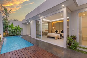 Une chambre moderne avec un grand lit, une porte en verre donnant sur une salle de bain et un espace piscine avec une terrasse en bois.