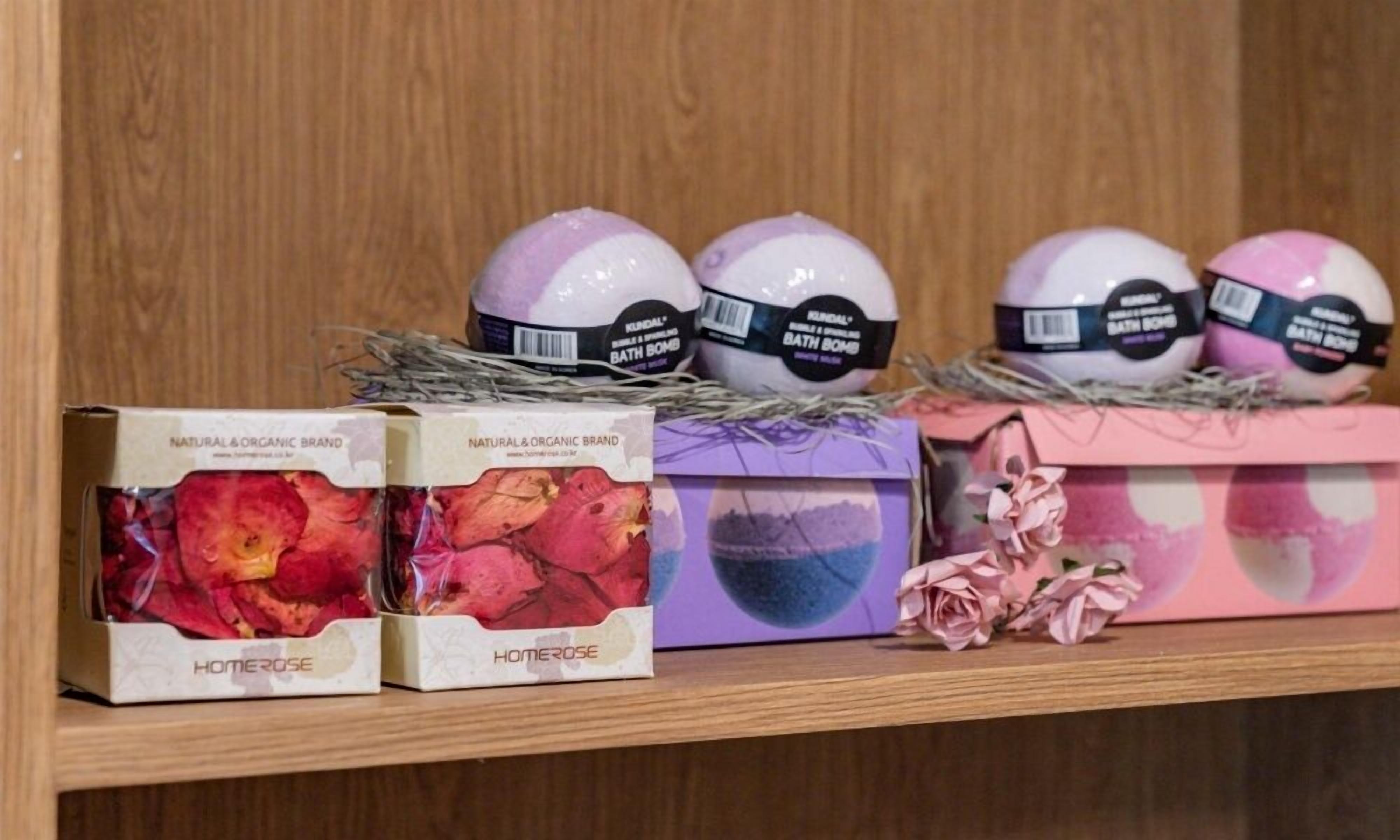 A shelf with bath bombs and rose petals.