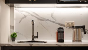 Une cuisine dotée d’un plan de travail en marbre, d’une machine à café et d’une bouilloire.