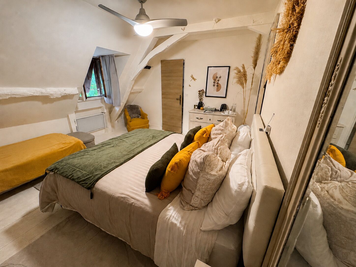 Une chambre à coucher avec un lit, une chaise, un bureau et un ventilateur de plafond.