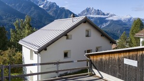 Un bâtiment blanc avec un toit en pente, une clôture en bois et un panneau indiquant un espace de stationnement.