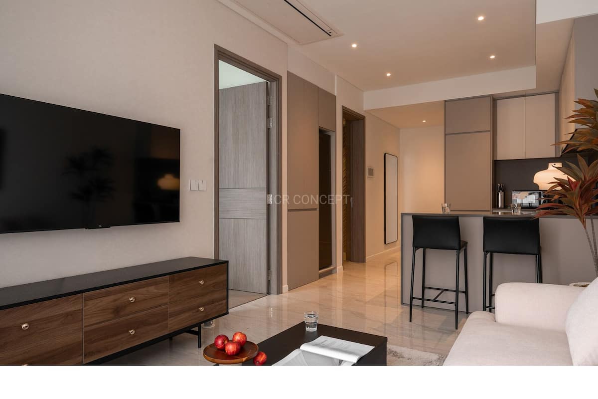Ein modernes Wohnzimmer mit Fernseher, Holzschrank, Couchtisch mit Äpfeln und einem Glas Wasser, sowie einer Couch.