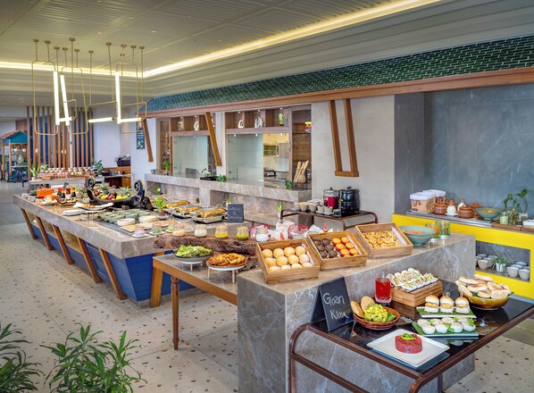 A buffet with various food items and a chalkboard sign indicating a 'Goan Kiosk'.
