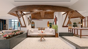 A modern interior with a central seating area, wooden beams, and artwork on the walls. - Gateway Goa, Palolem (Canacona)