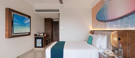 Et moderne hotelværelse med seng, natbord og ventilator.